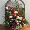 Holiday floral arrangement with red and white roses in a decorative basket