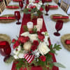 Red and white rose centerpiece on a decorated table with candles