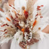 Bride holding a dried bouquet with white and rust accents