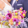 Bride and groom holding a colorful wedding bouquet