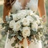 Bride holding a bouquet of white roses and eucalyptus