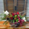 Holiday floral arrangement with red and white flowers in a basket