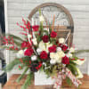 Holiday floral arrangement with red and white roses in a white vase