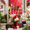 Red roses and white lilies in a red glass vase