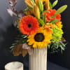 Sunflowers and orange gerbera daisies in a tall striped vase