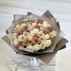 Bouquet of cream and blush roses wrapped in brown and white paper