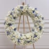 Large white floral wreath on a wooden easel