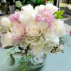 Pink and white bouquet of roses and hydrangeas in a clear glass vase