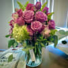 Pink roses and hydrangea in a clear glass vase