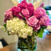 Pink and magenta roses with white hydrangeas in a glass vase