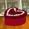 Heart-shaped arrangement of red and white roses in a red box