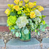 Yellow roses and white hydrangeas in a glass vase