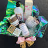 Bath and body gift basket with bottles, jars, and a pink bow