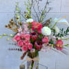 Pink roses and white calla lilies in a glass vase with a ribbon