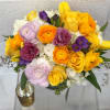 Bouquet of yellow, orange, purple, and white flowers in a vase