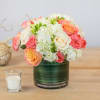 Bouquet of pink, peach, and white roses in a green glass vase