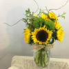 Sunflower arrangement in a glass vase with curly branches