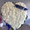 Heart-shaped white floral wreath with a blue ribbon reading SON