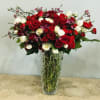 Red and white roses arranged in a tall glass vase