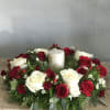 Red and white rose centerpiece with a white pillar candle