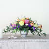 Mixed bouquet of roses and lilies in a silver vase