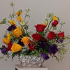 Bouquet of red, yellow, and purple roses in a silver vase