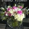 Pink roses and white hydrangeas in a round glass vase