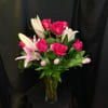 Pink roses and white lilies arranged in a clear glass vase