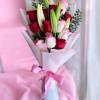 Bouquet of red and pink roses with lily buds wrapped in pink paper