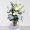 Blue and white floral arrangement in a clear glass vase