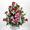 A lush upright display of red roses and pink lilies, this basket