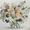 Cream roses and white lilies in a round glass vase