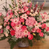 Large pink floral arrangement in a decorative vase