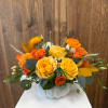 Yellow and orange rose arrangement in a white pumpkin vase