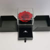 Red rose in a clear box with a ring in a black jewelry box