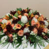 Large floral arrangement with peach roses, white hydrangeas, and orange orchids