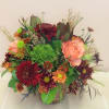 Mixed bouquet with peach roses and burgundy chrysanthemums in a glass vase