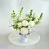 White rose arrangement in a white vase with black ribbon