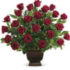 Red roses arranged in a dark urn vase
