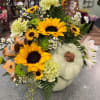 Pumpkin-shaped floral arrangement with sunflowers and pale green carnations