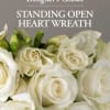 White roses and calla lilies arranged in a standing heart wreath.