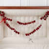 Red floral garlands draped across a white upholstered headboard