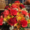 Basket arrangement of red, orange, and yellow flowers