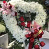 Heart-shaped floral wreath with white chrysanthemums, red roses, and pink lilies