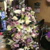 Large pastel floral spray with lilies, roses, daisies, and purple filler flowers