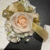 Cream rose corsage with gold ribbon and small white flowers