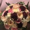 Bouquet of pink, cream, and burgundy roses with baby's breath