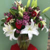 Bouquet of white lilies and red roses in a glass vase