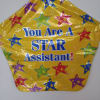 Yellow star-shaped balloon with multicolored stars and the words "You Are A STAR Assistant!"