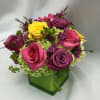 Colorful rose bouquet in a green square vase